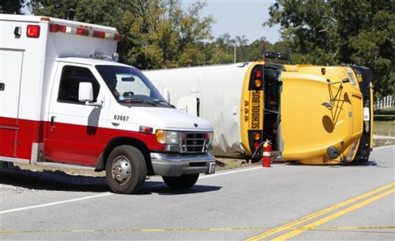An ambulance leaves the scene where a school bus overturned on Highway 113 between Temple and Carrollton, Ga., Monday.